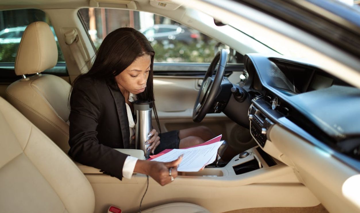 Woman Reading Documents while in Her Car