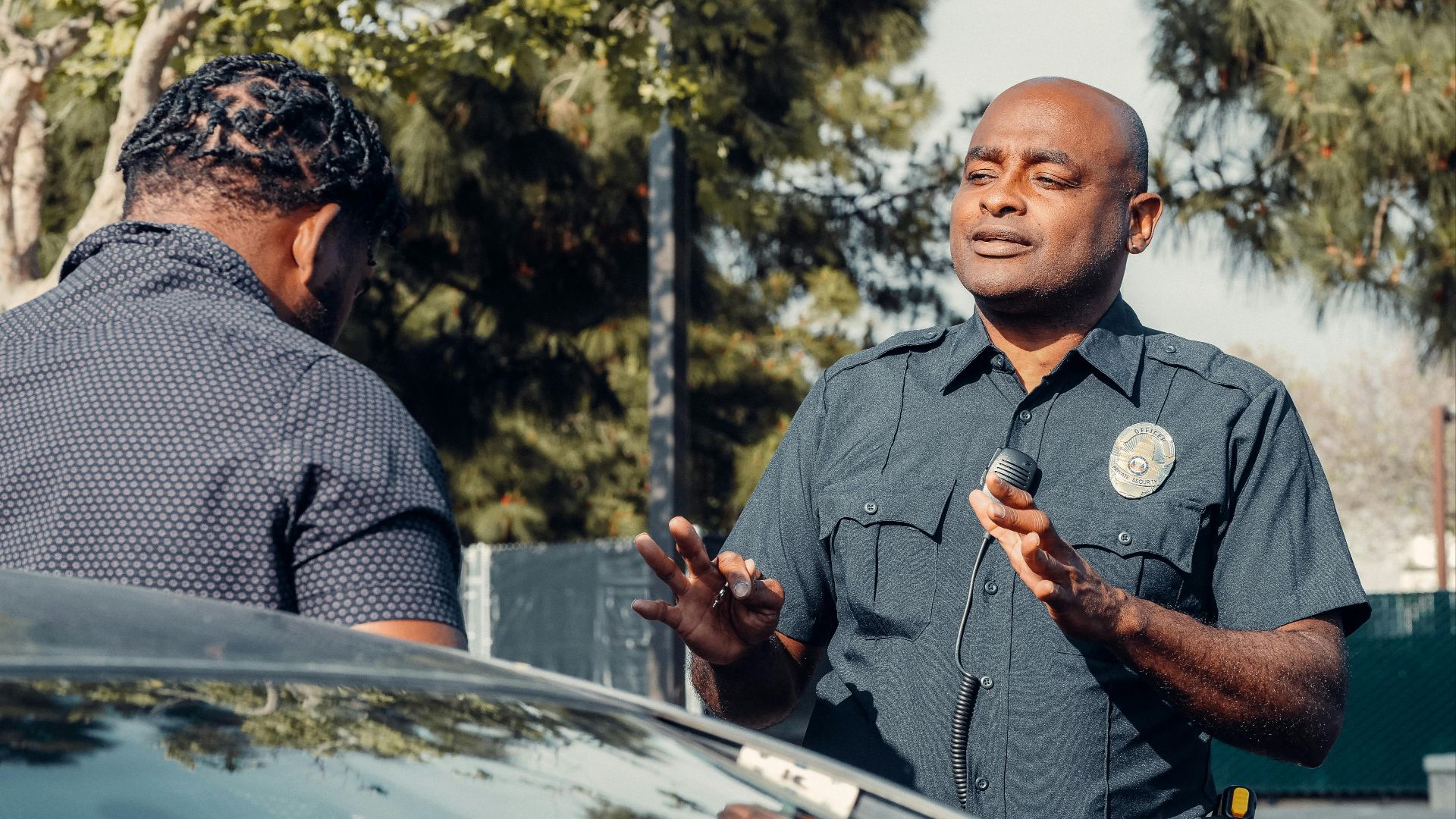 A police officer engages in conversation outdoors, reflecting community service and law enforcement.
