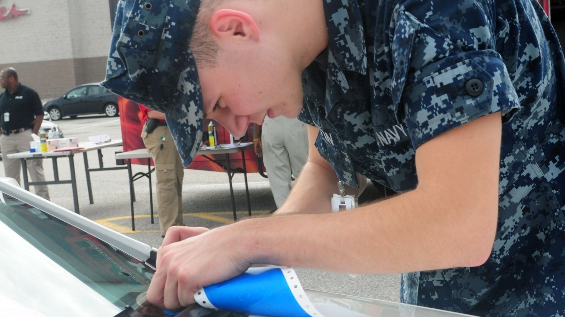 Hospital Corpsman William Wooten, temporarily assigned to the Naval Station Norfolk Police Precinct, etches vehicle identification numbers onto a car in the Navy Exchange parking lot Oct. 3. HEAT (Help Eliminate Auto Theft) provided a free VIN etching service to service members. (U.S. Navy photo by Mass Communication Specialist 3rd Class Molly Anne Greendeer)