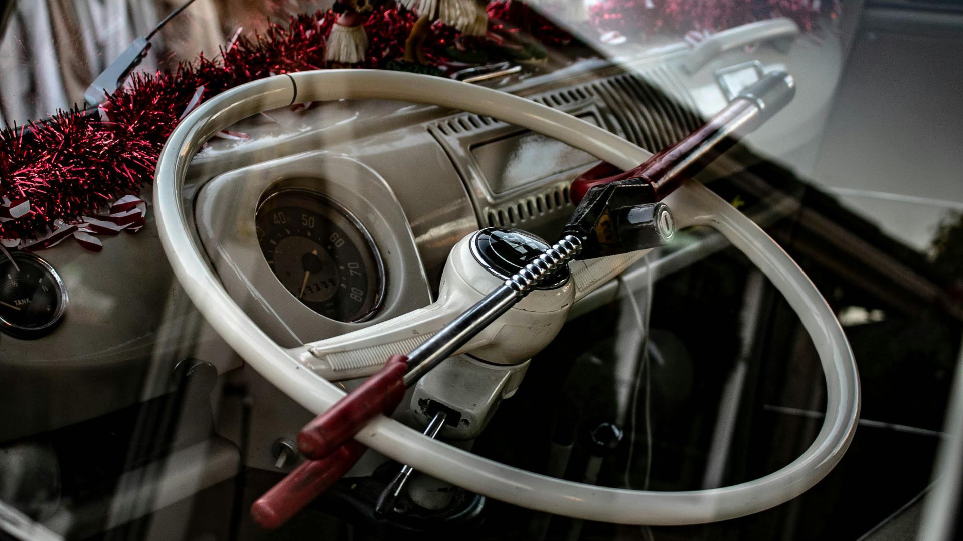 Close-up of a classic car's steering wheel with an anti-theft lock.