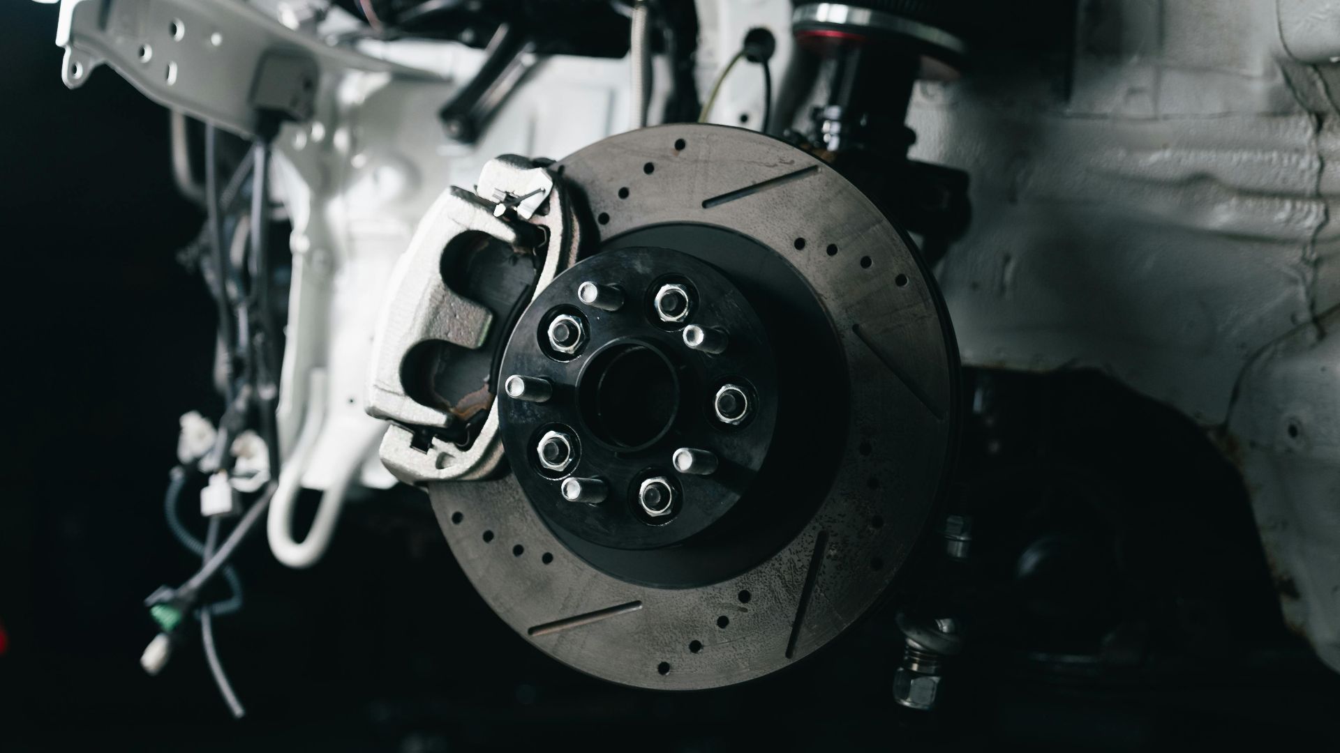 Detailed view of a vehicle's disc brake system with caliper, showcasing automotive technology.