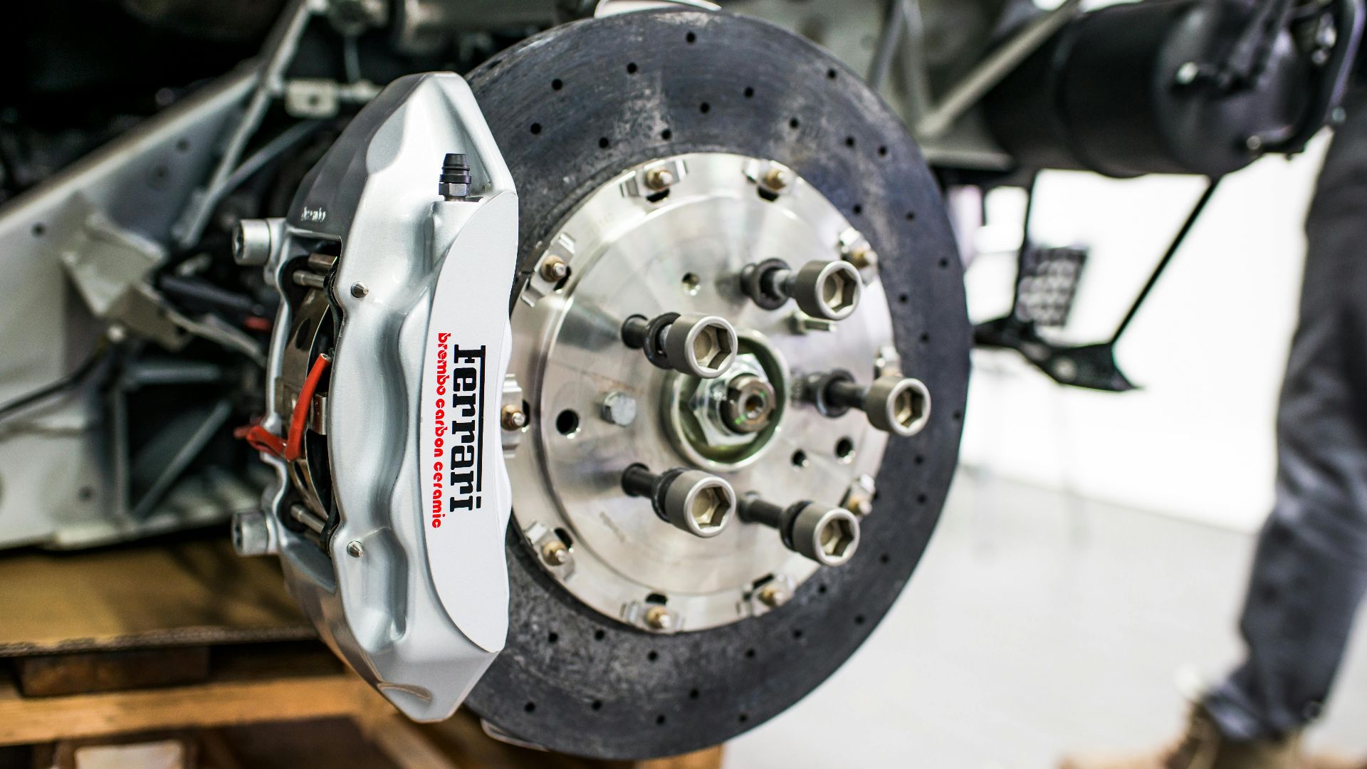 Detailed view of disc brake and caliper on a high-performance car, emphasizing precision and technology.