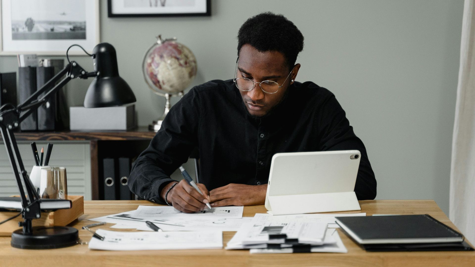 Businessman in a modern office working on documents using a digital tablet.