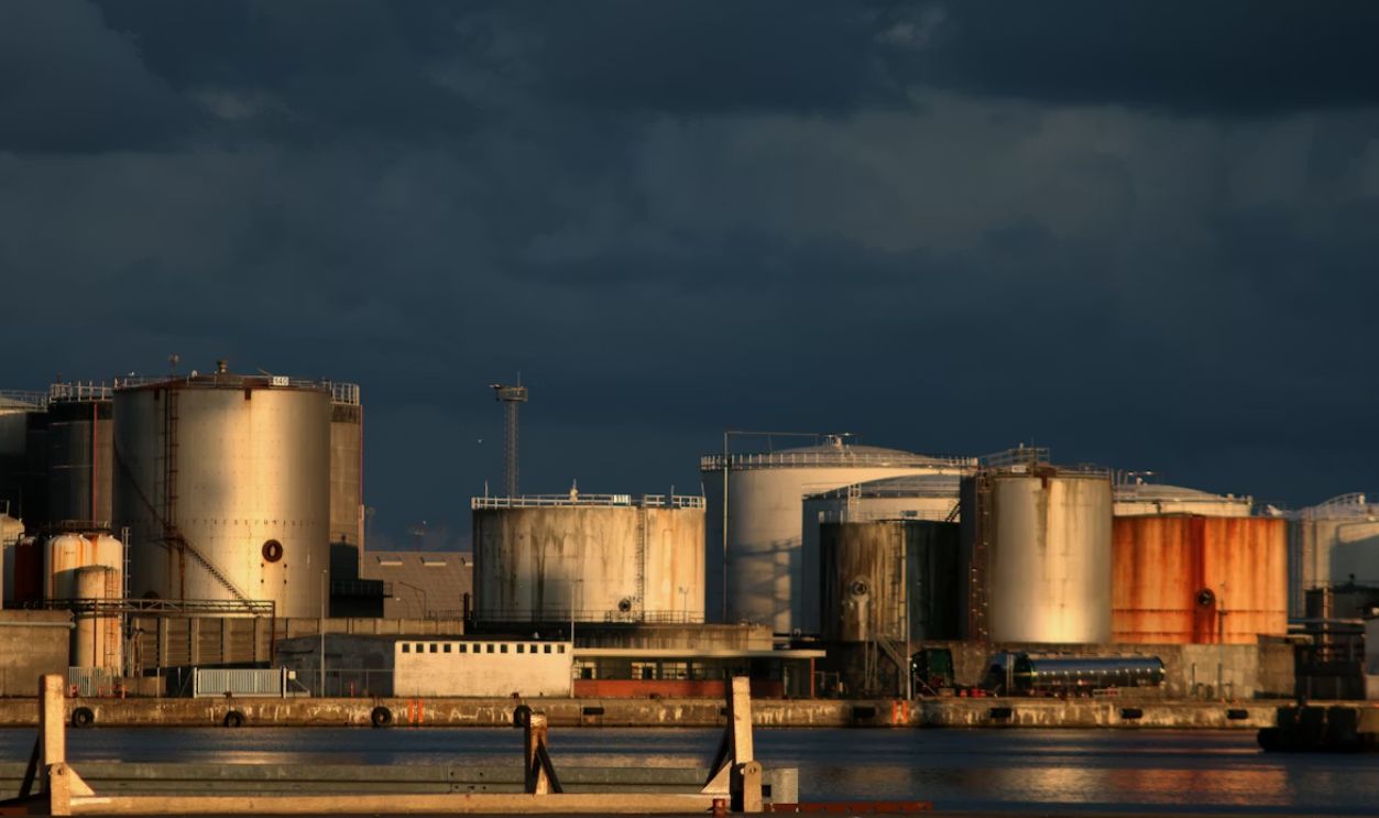 a large industrial area with a body of water in front of it