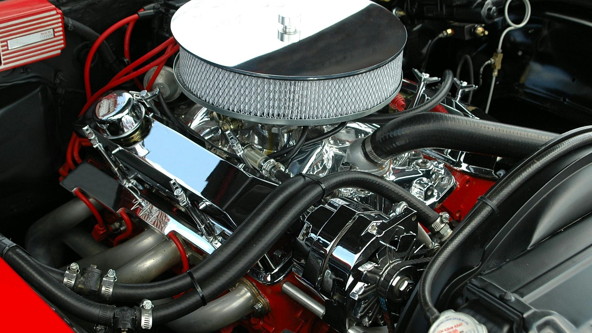 Detailed view of a polished, high-performance car engine showcasing chrome detailing and intricate mechanics.