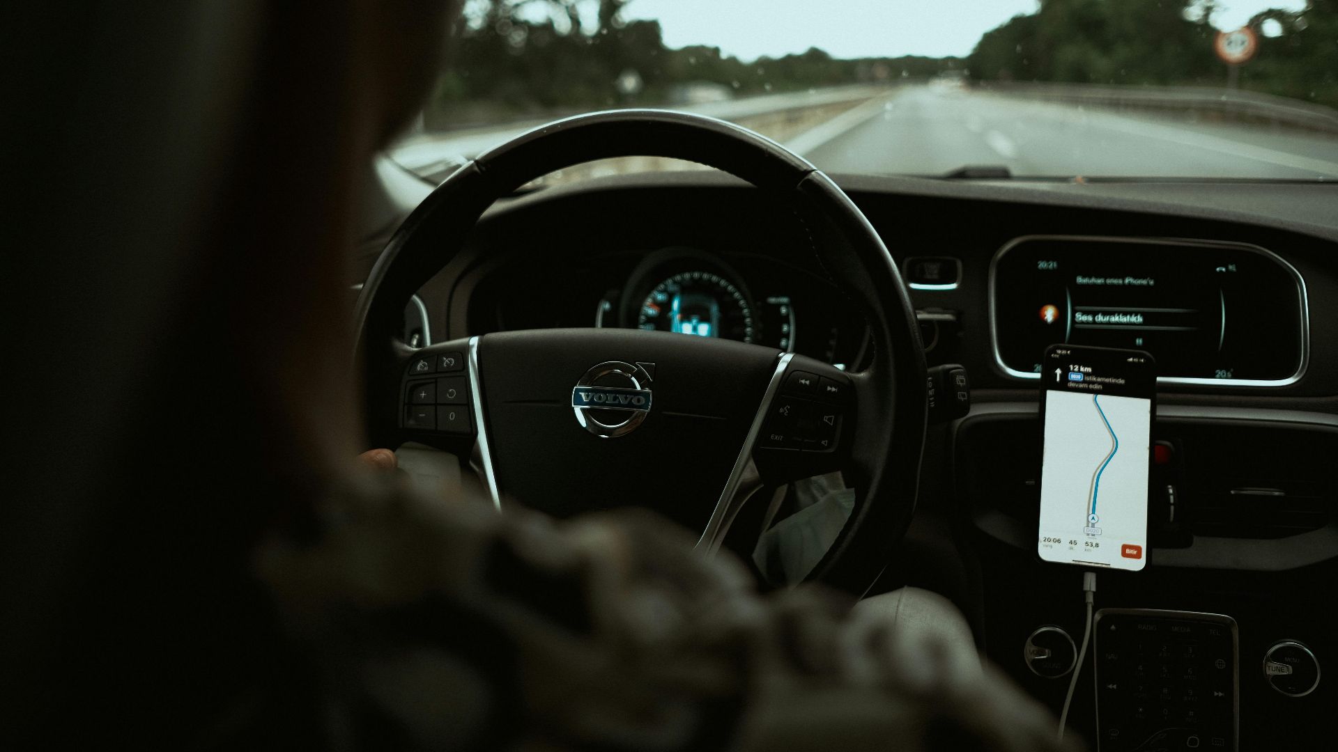 Interior view of a car on the highway using a GPS navigation app on a smartphone