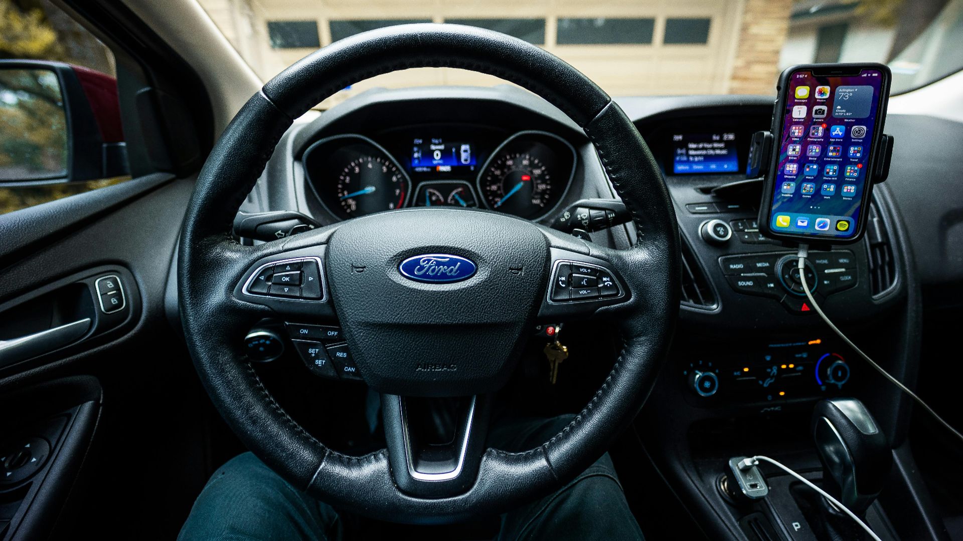 Interior view of a Ford car featuring a steering wheel, dashboard, and mobile device mount.