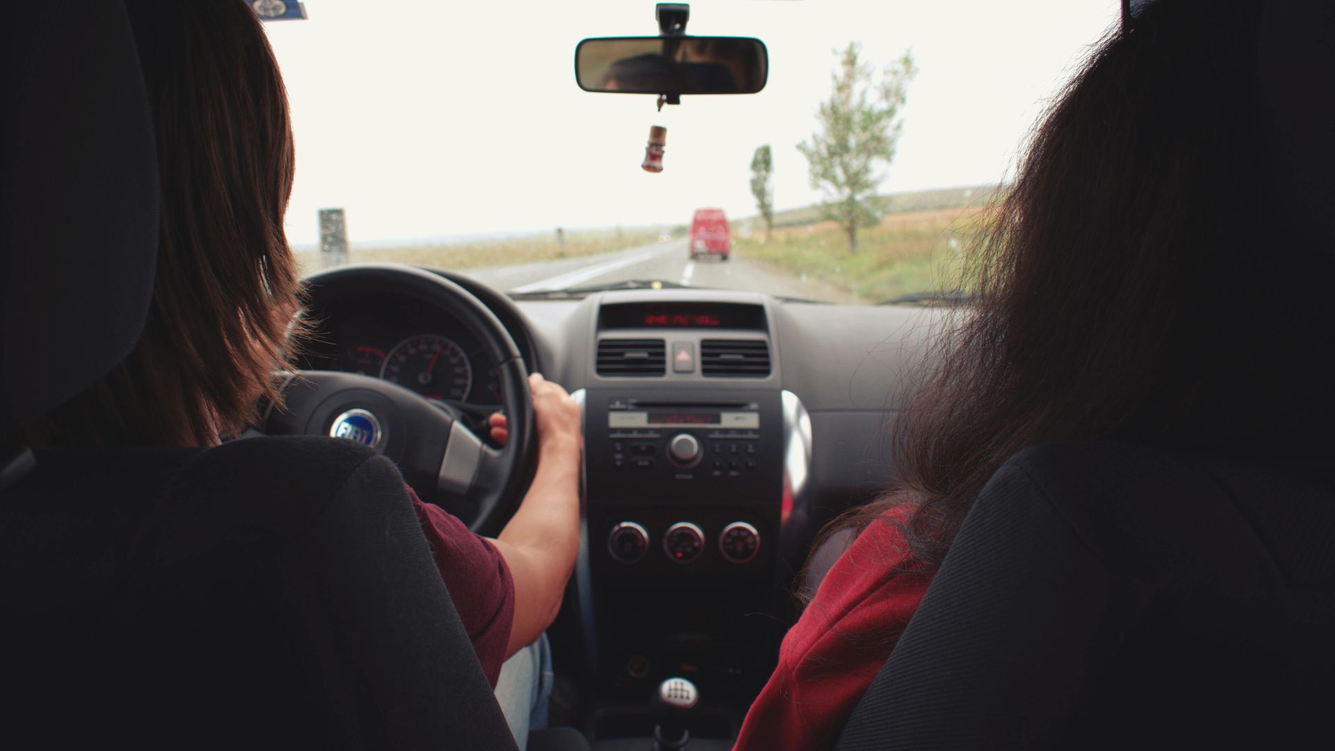 Two adults traveling by car on a scenic road near Iași, Romania.