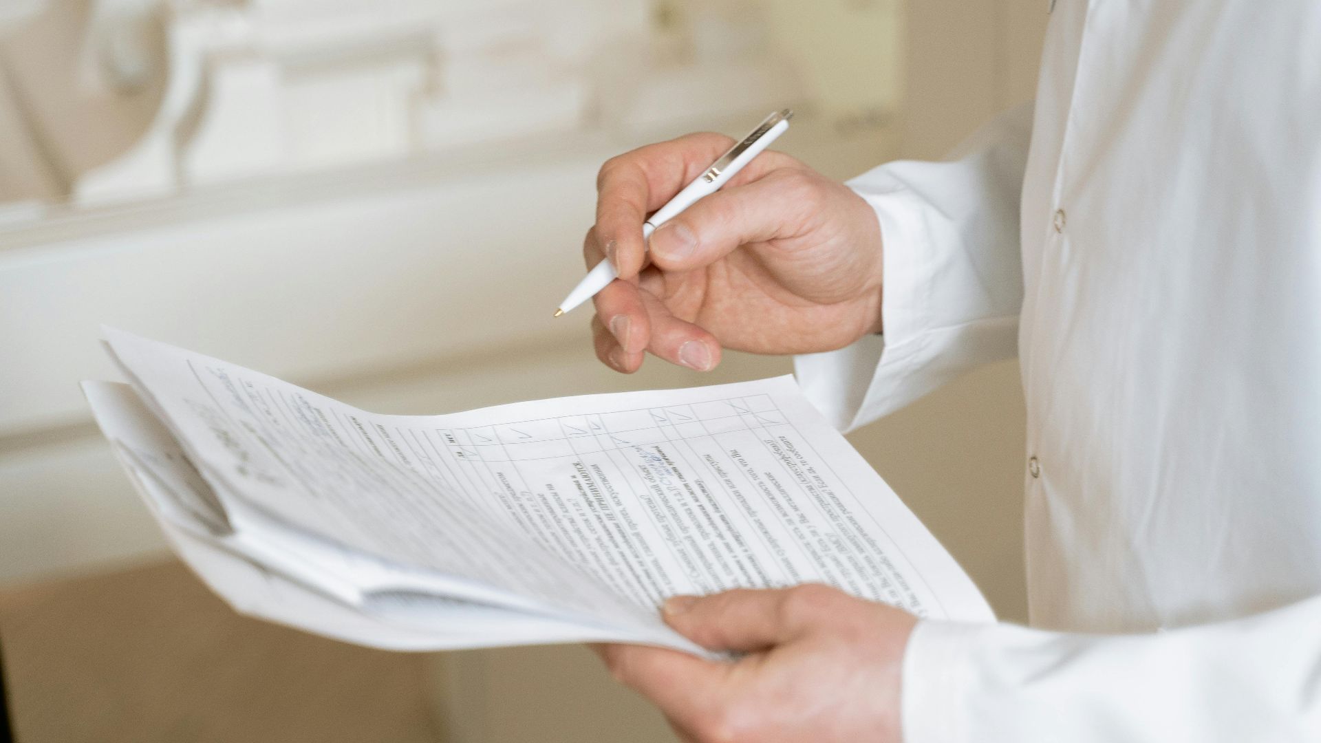 A doctor holds and reviews medical documents, demonstrating careful examination and professionalism.