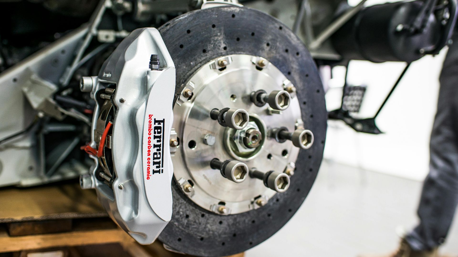 Detailed view of disc brake and caliper on a high-performance car, emphasizing precision and technology.