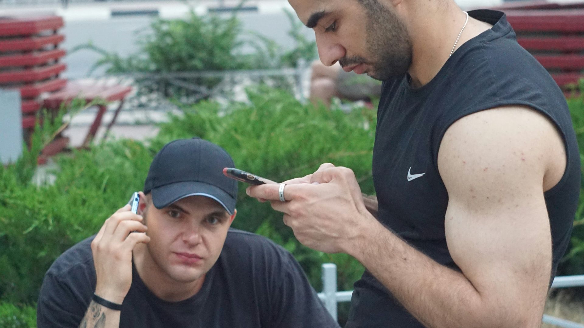 A man sitting next to a man who is smoking a cigarette