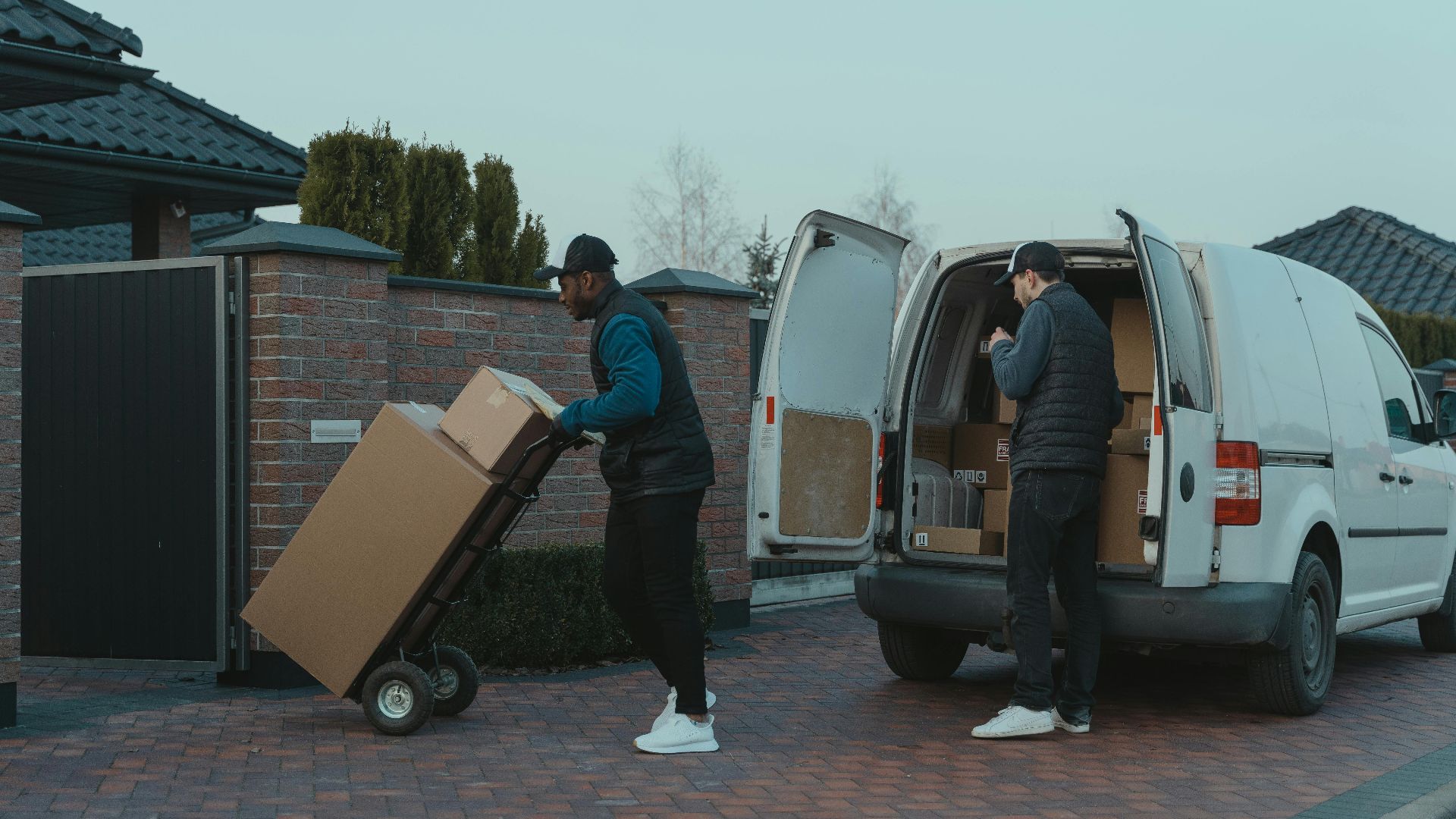 Two delivery men working diligently from a van, showing teamwork and logistics efficiency.
