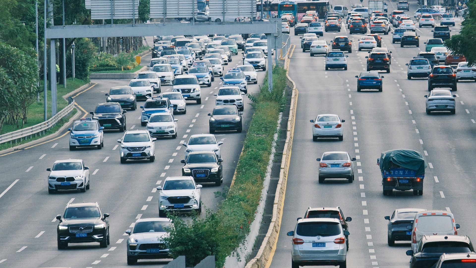a highway filled with lots of traffic next to tall buildings