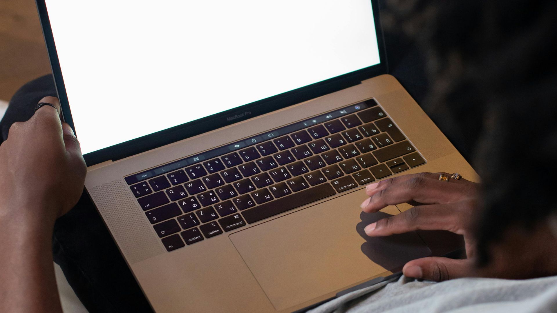 African American man using a laptop with blank screen indoors.
