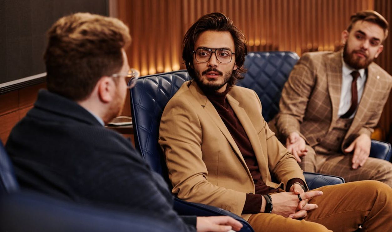 Three Businessmen Sitting in a Room Having a Conversation