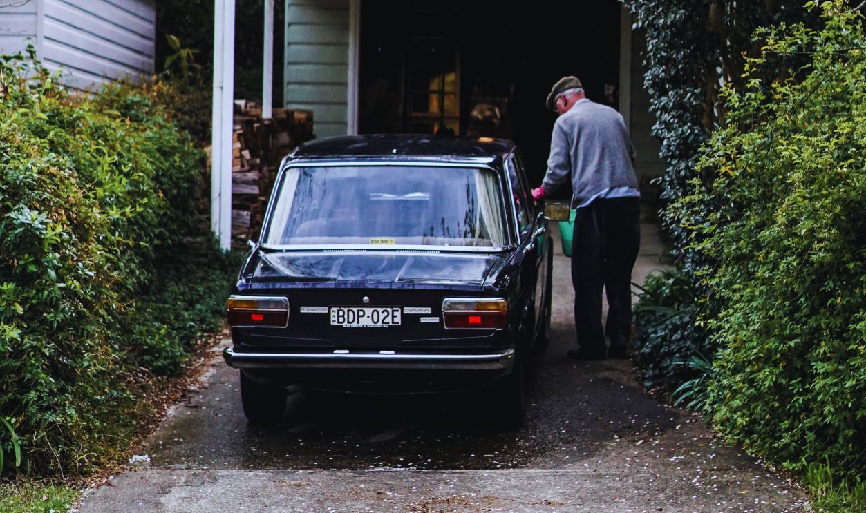 Photo Of Man Standing Beside Vehicle