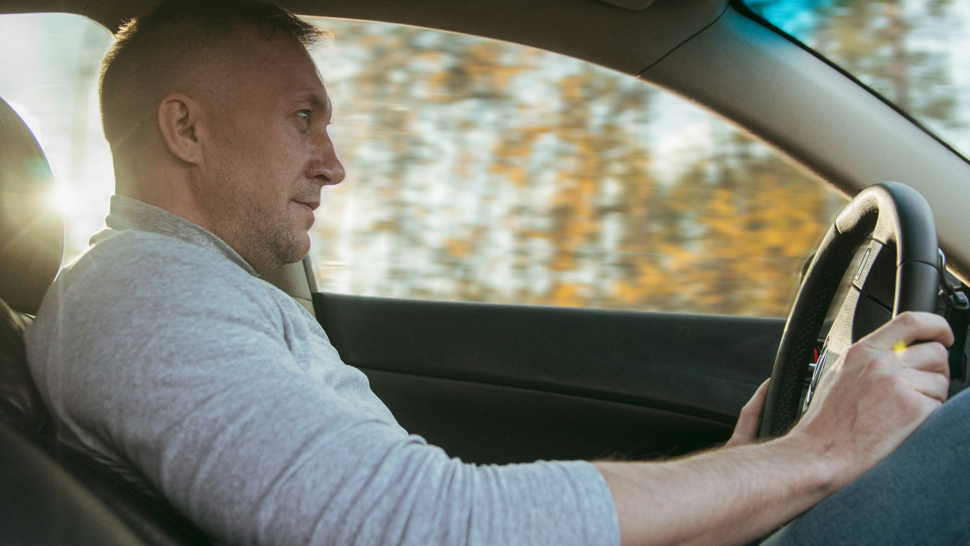 Man driving a car on a sunny day