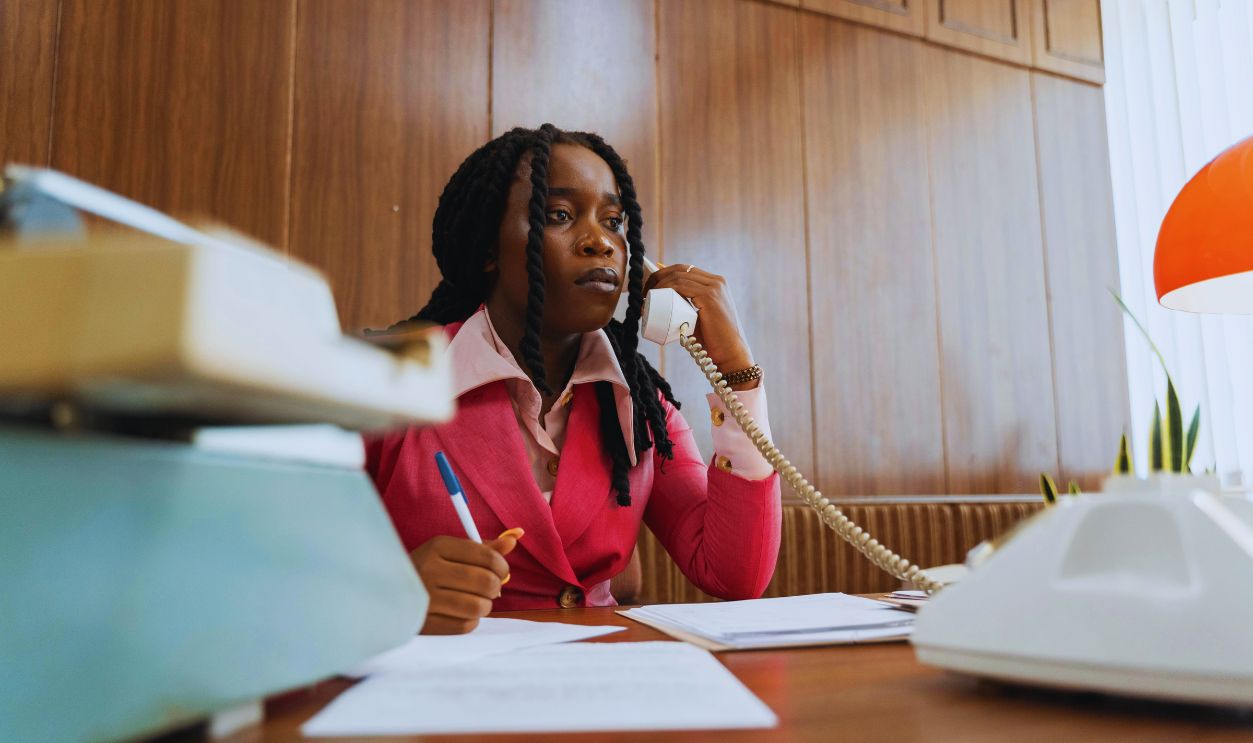 A Businesswoman Holding a Pen while on a Phone Call