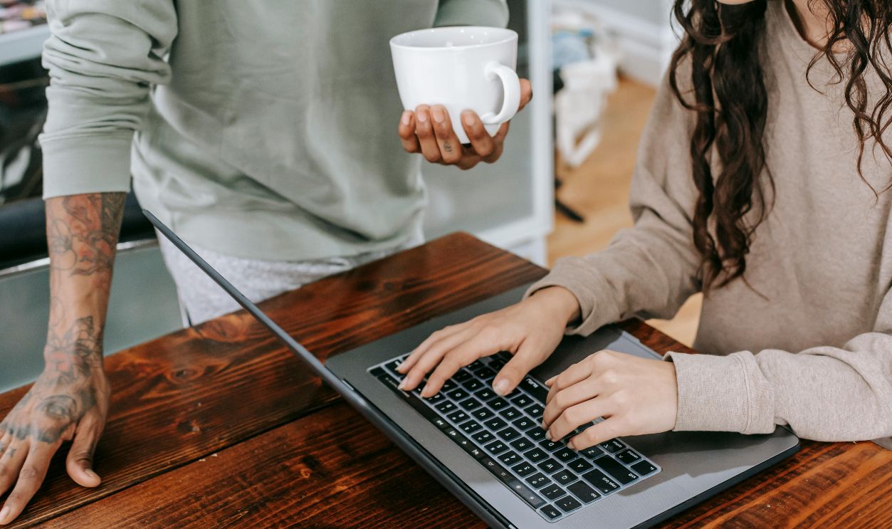 Woman In Brown Long Sleeve Shirt Using Macbook Pro