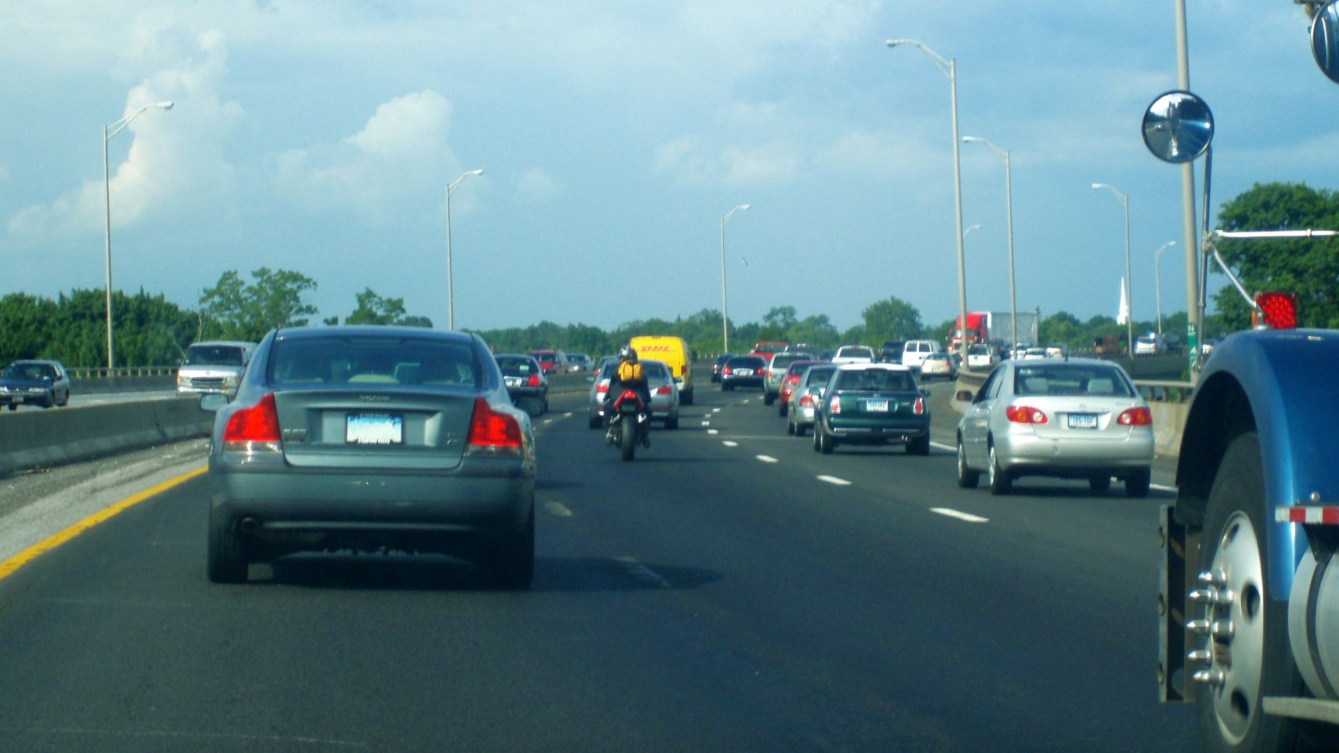 a motorcycle and cars driving down the road