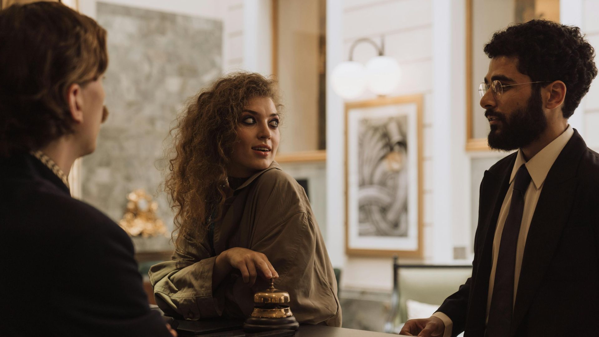Guests interacting at a luxurious hotel reception desk, emphasizing hospitality and service.