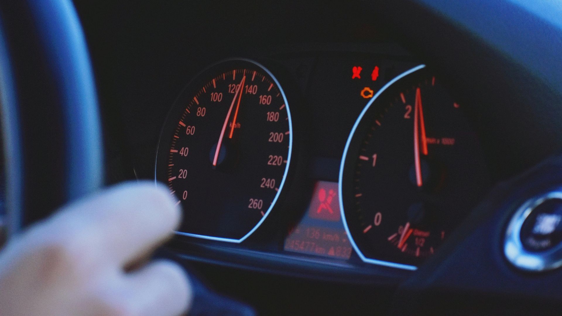 A detailed view of a car's speedometer and dashboard, emphasizing speed and technology.