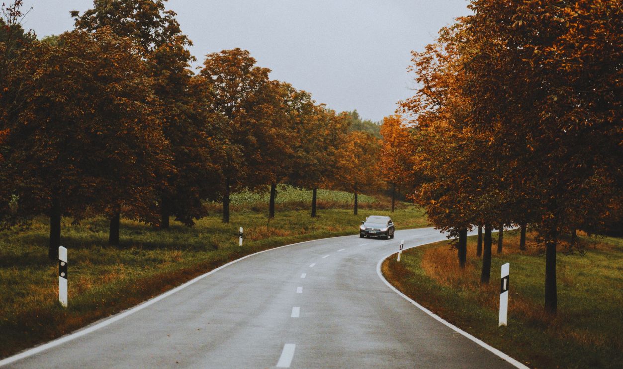A Car Driving on an Asphalt Road
