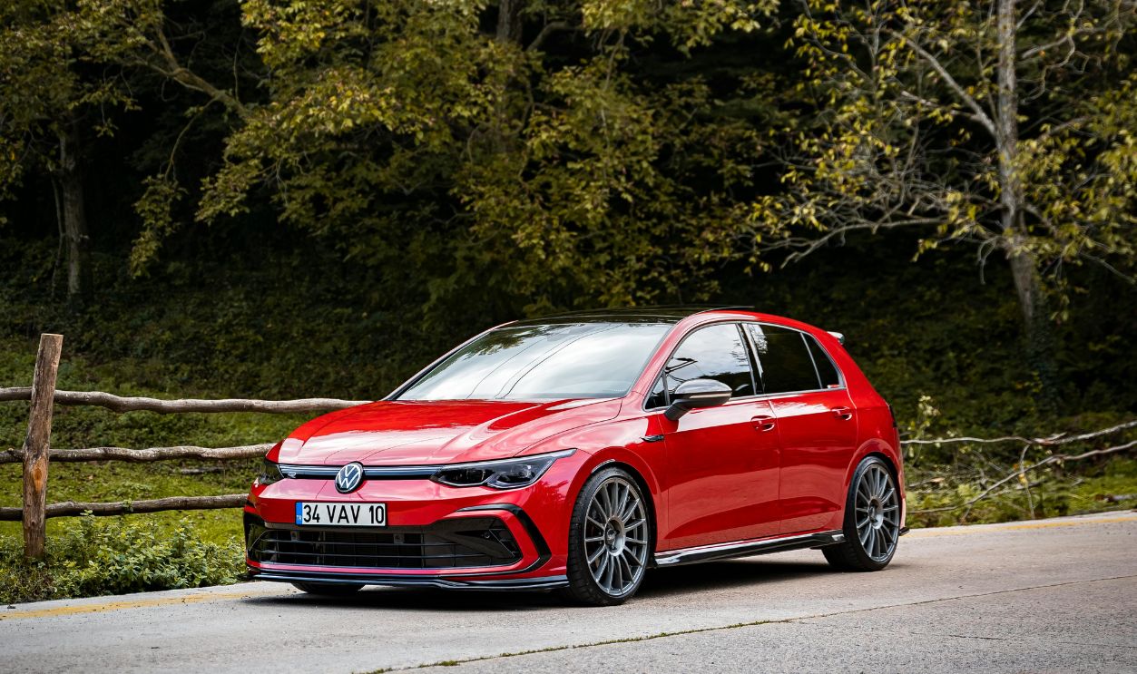 A Red Car Parked on the Road Near the Trees
