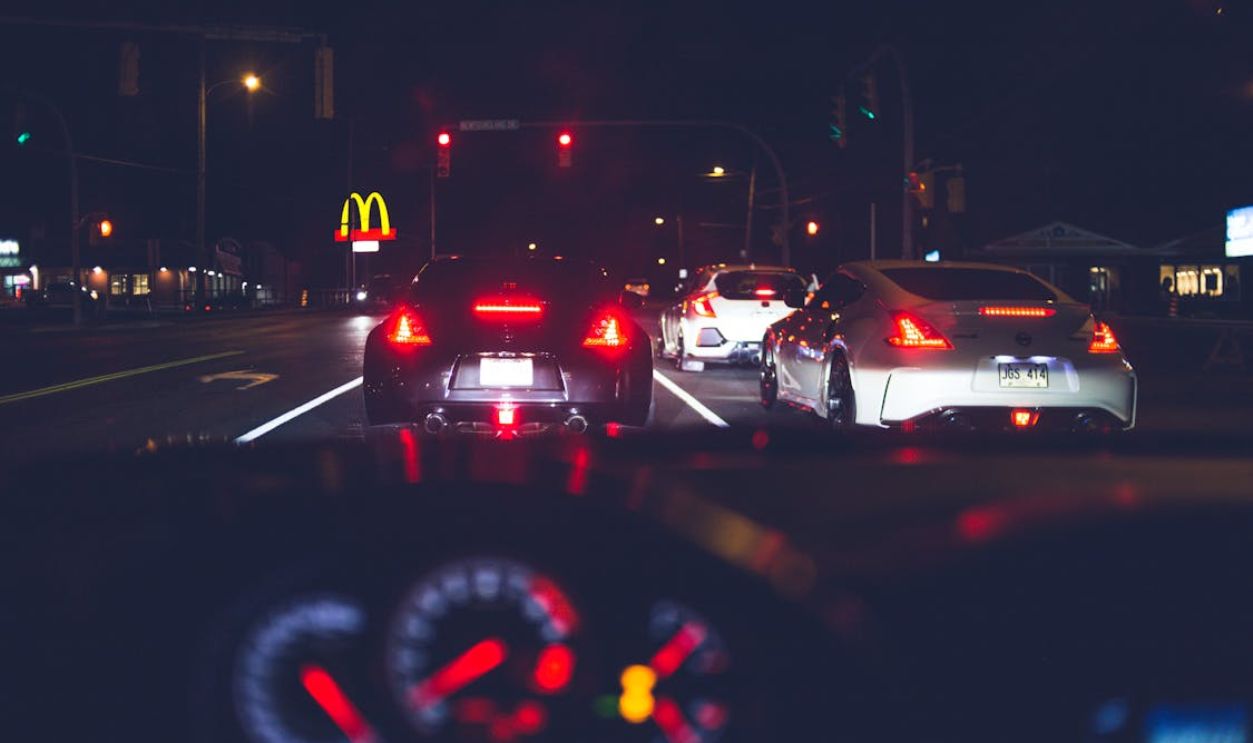 Various modern vehicles riding on street at night
