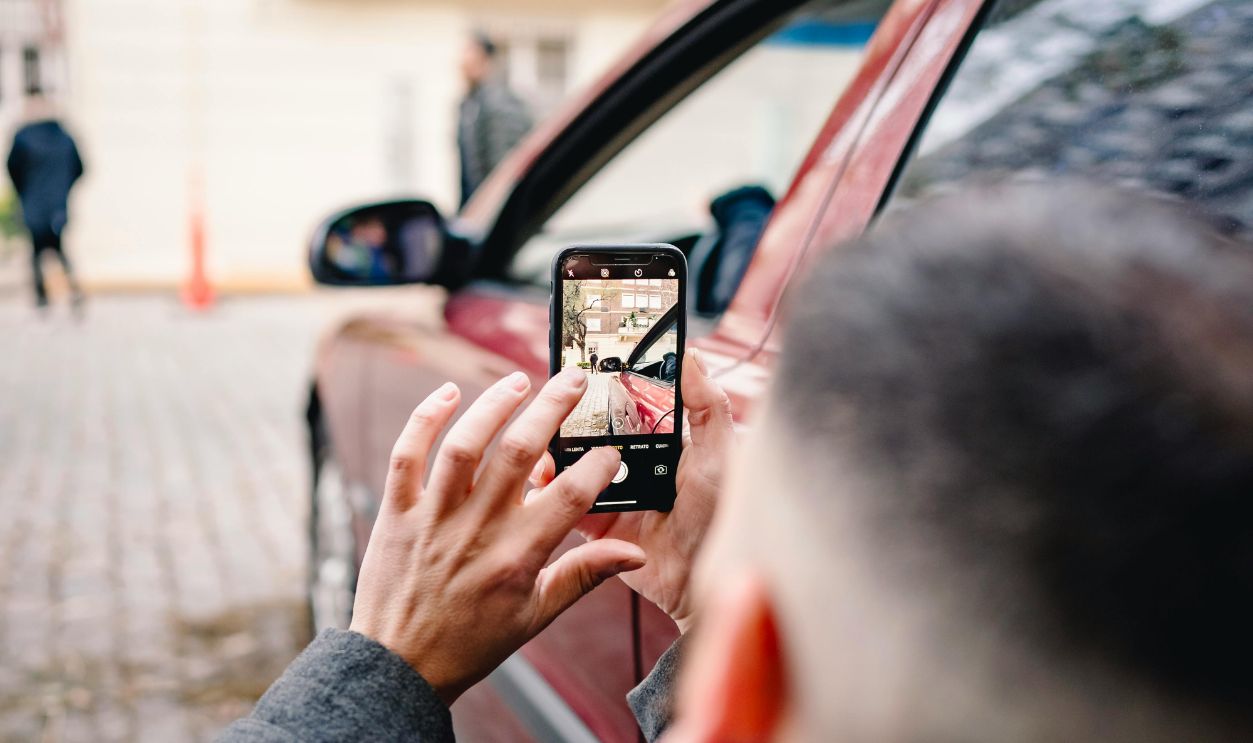 Man Taking Pictures near Car