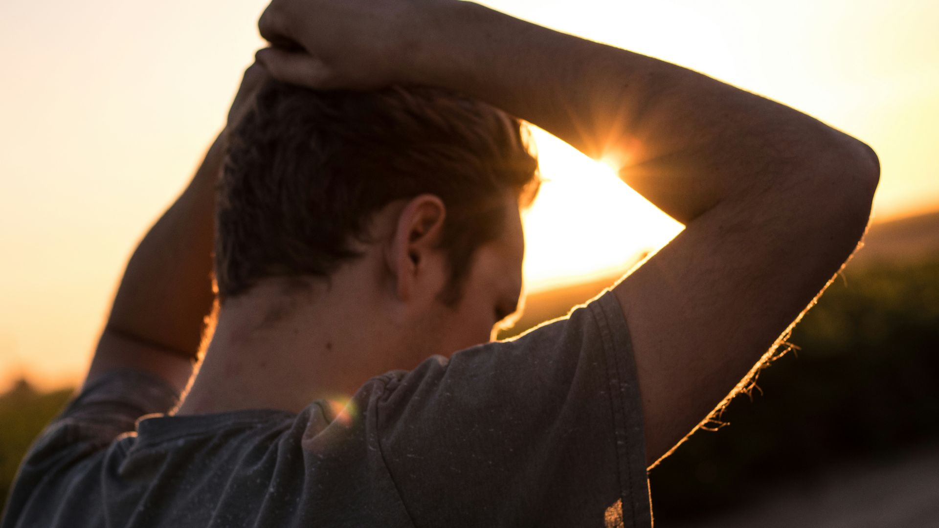 man holding his hair against sunlight