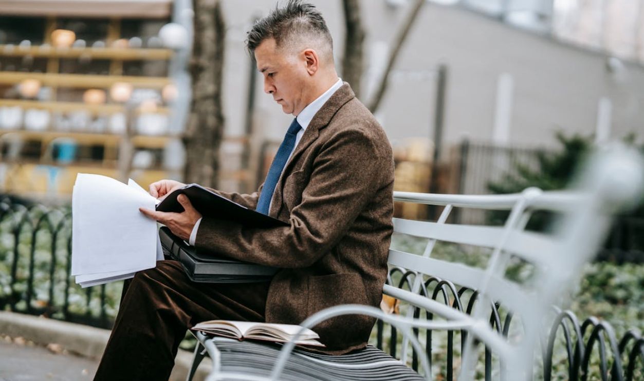 Photo Of Man Looking Through Papers
