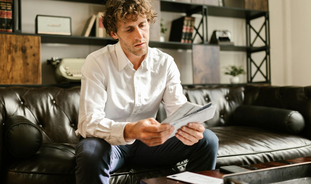 Man in White Long Sleeve Shirt Sitting on Sofa