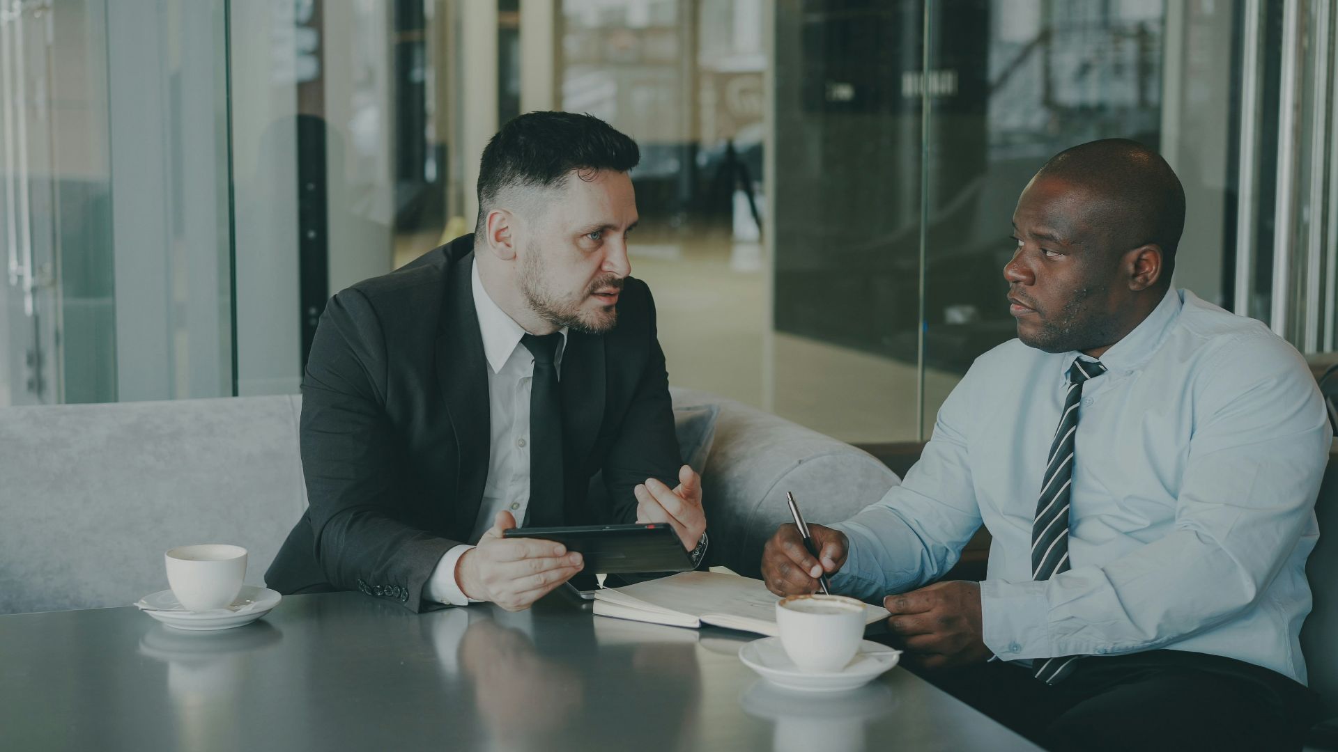 Two businessmen discussing work over coffee.
