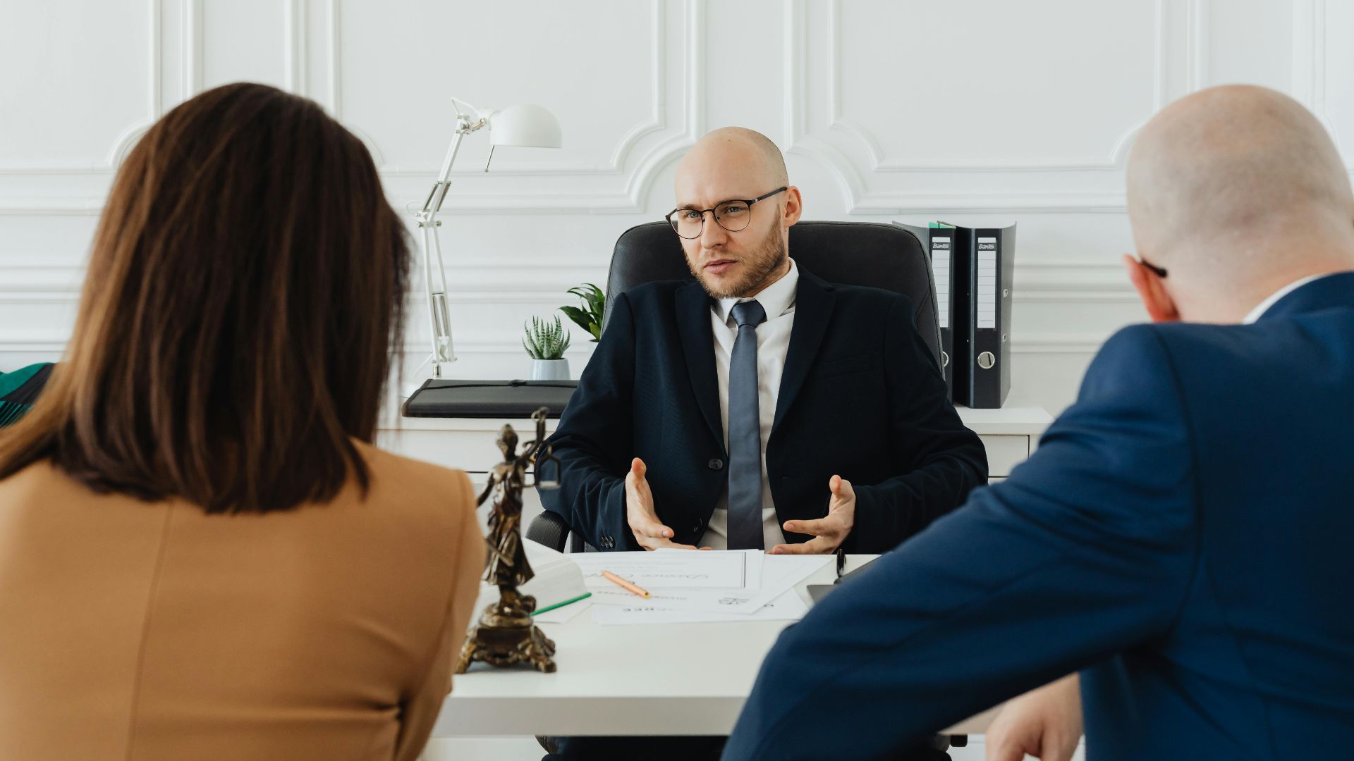A professional business meeting with a lawyer and clients in a modern office setting.