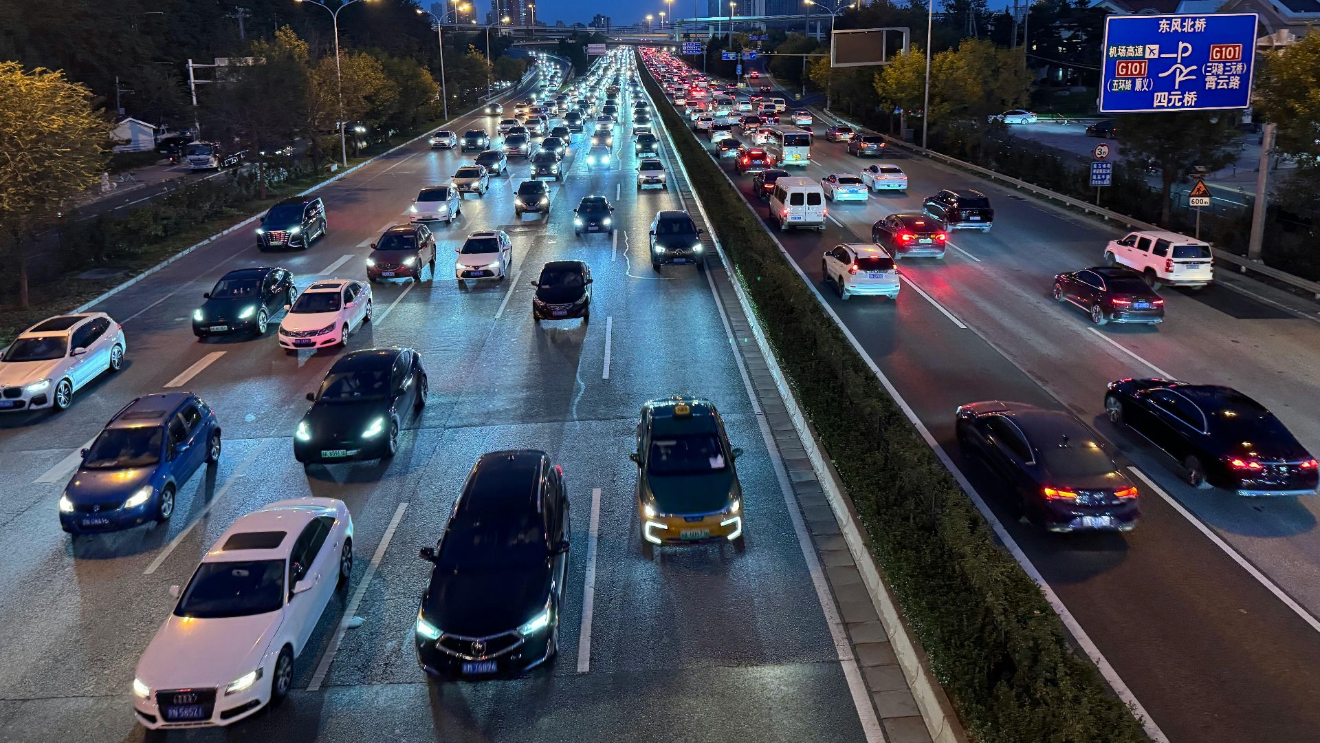 Evening view of busy traffic on a Beijing highway with illuminated city lights.
