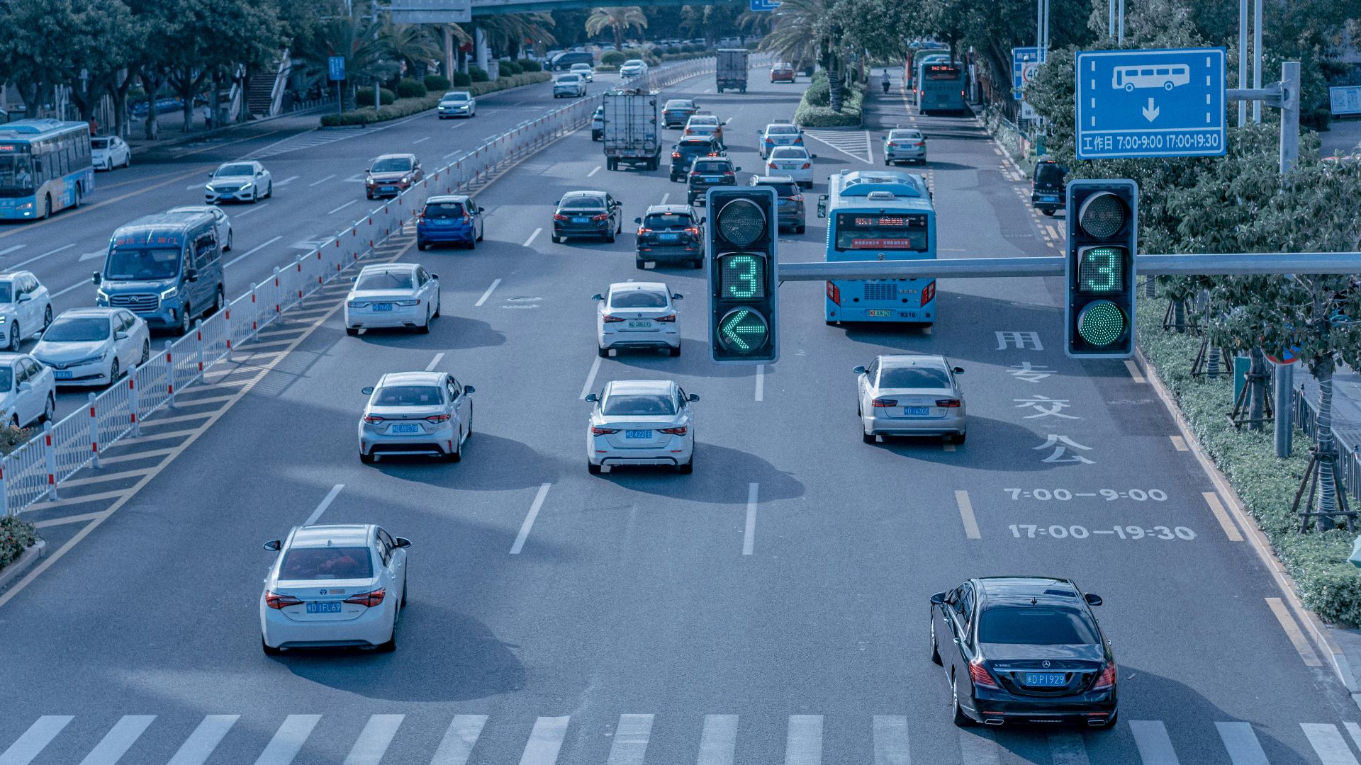Wide shot of urban traffic at a busy city intersection with cars and buses.