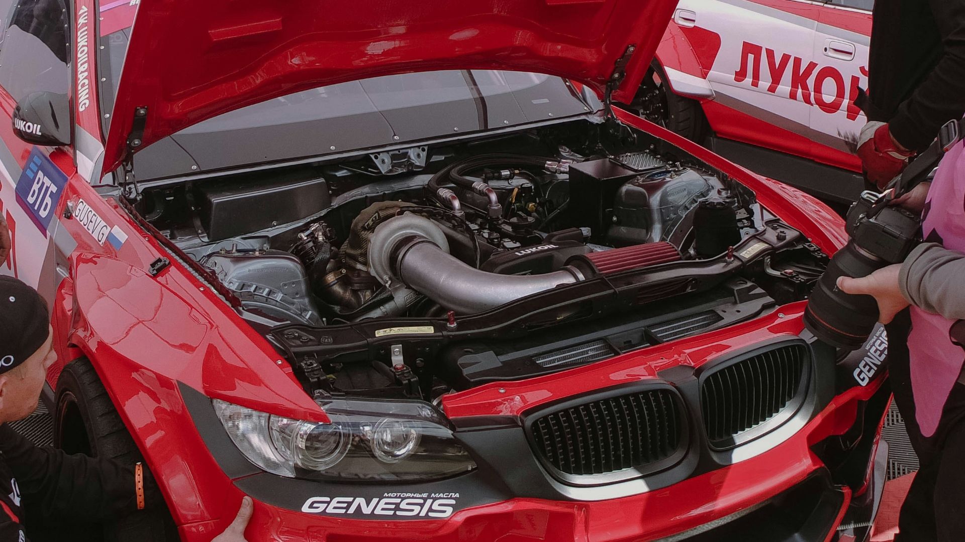 a group of men working on a red car