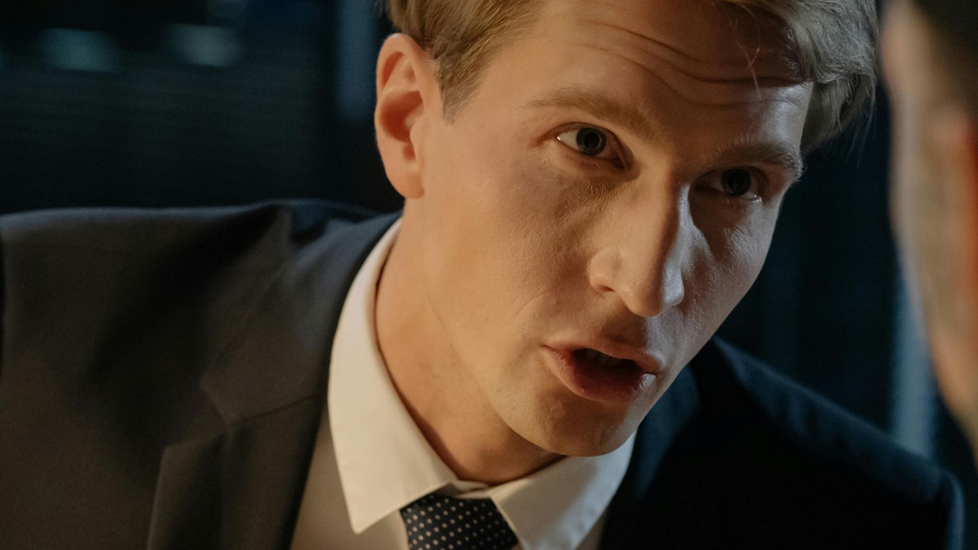 Close-up of a professional man in a suit engaged in a serious discussion.