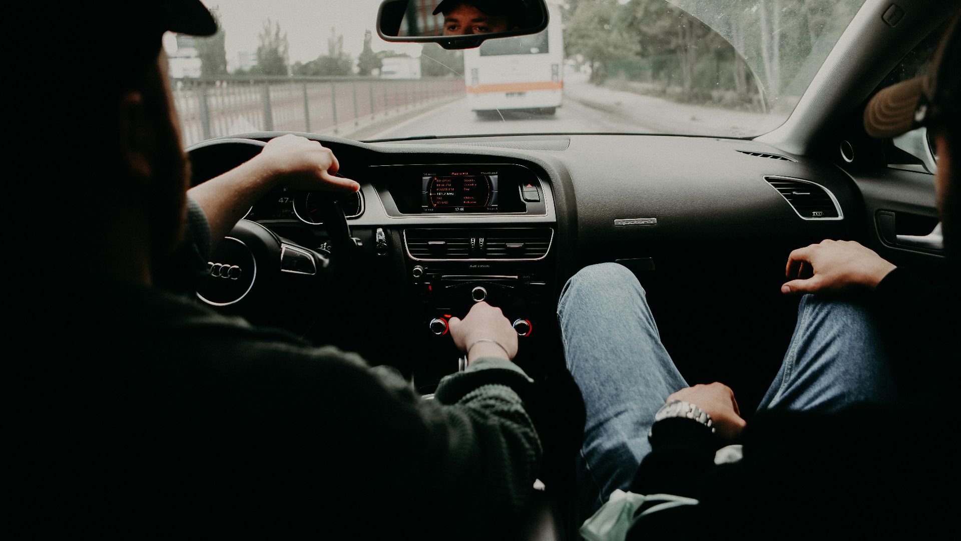 View from inside a moving car with two men traveling on a road trip.