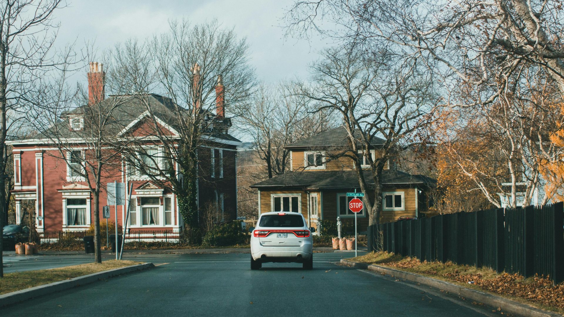 A scenic suburban street with vibrant autumn foliage and traditional houses.