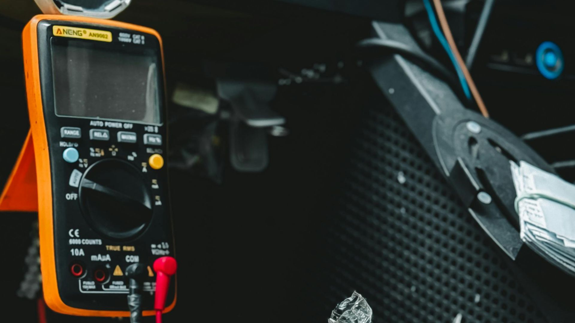 Neatly arranged tools on a workbench, featuring pliers, screwdrivers, and a multimeter.