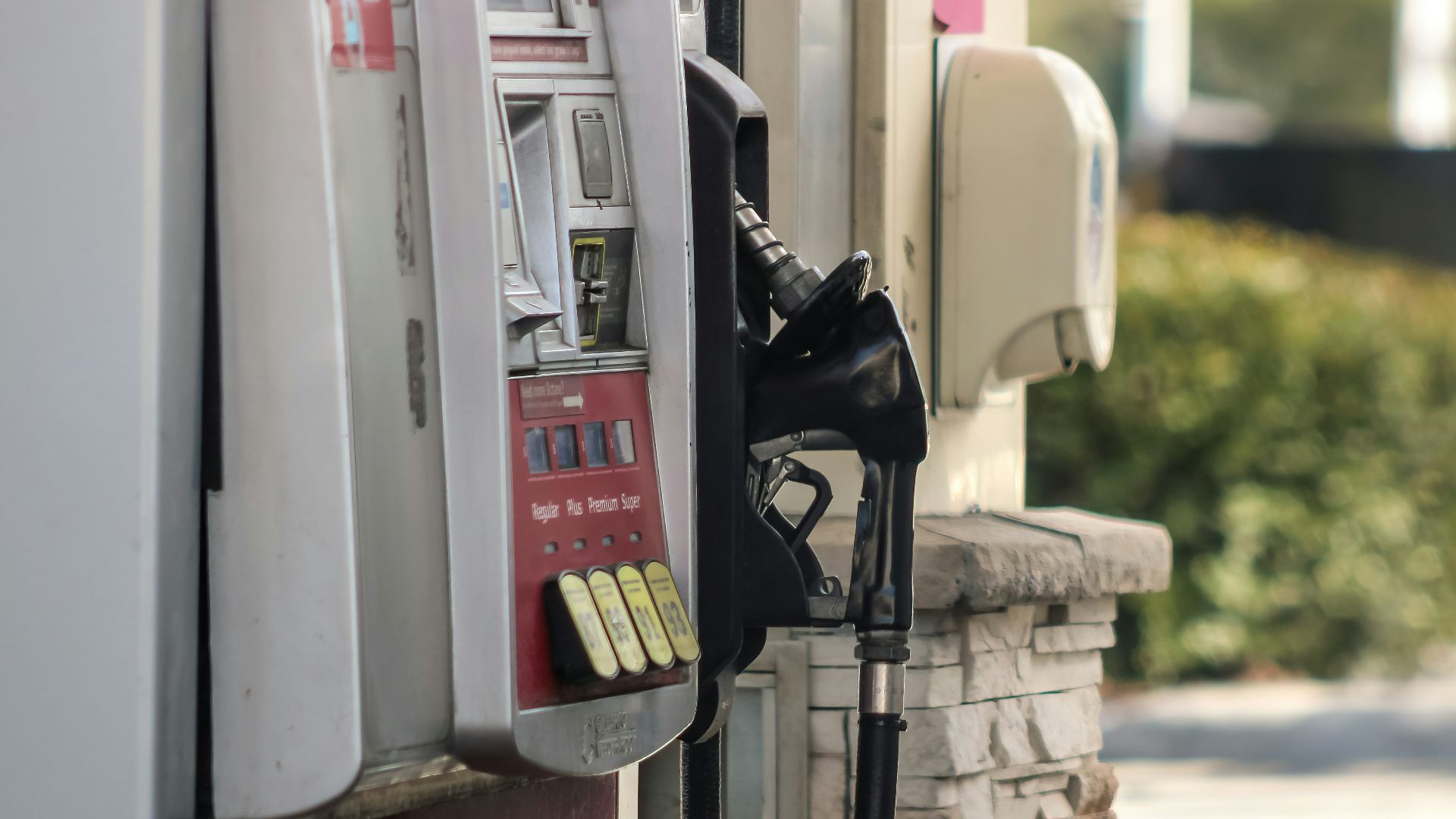 a gas pump next to a brick wall