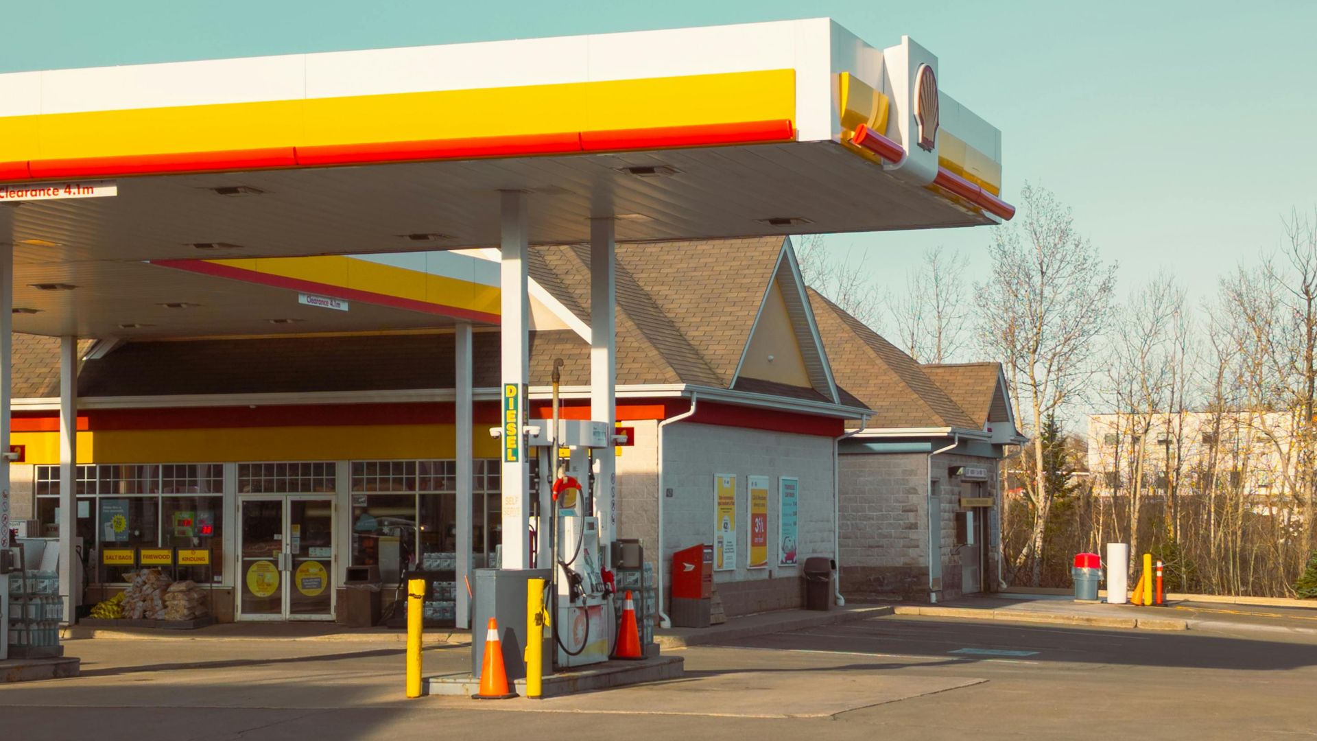 A quiet and empty gas station under a clear blue sky with no people in sight.
