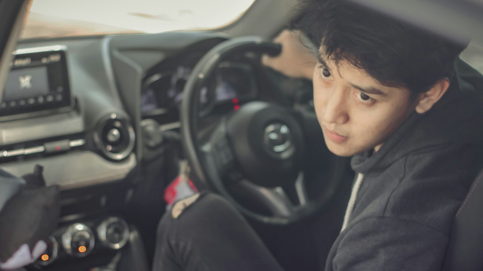 woman in black hoodie sitting on drivers seat