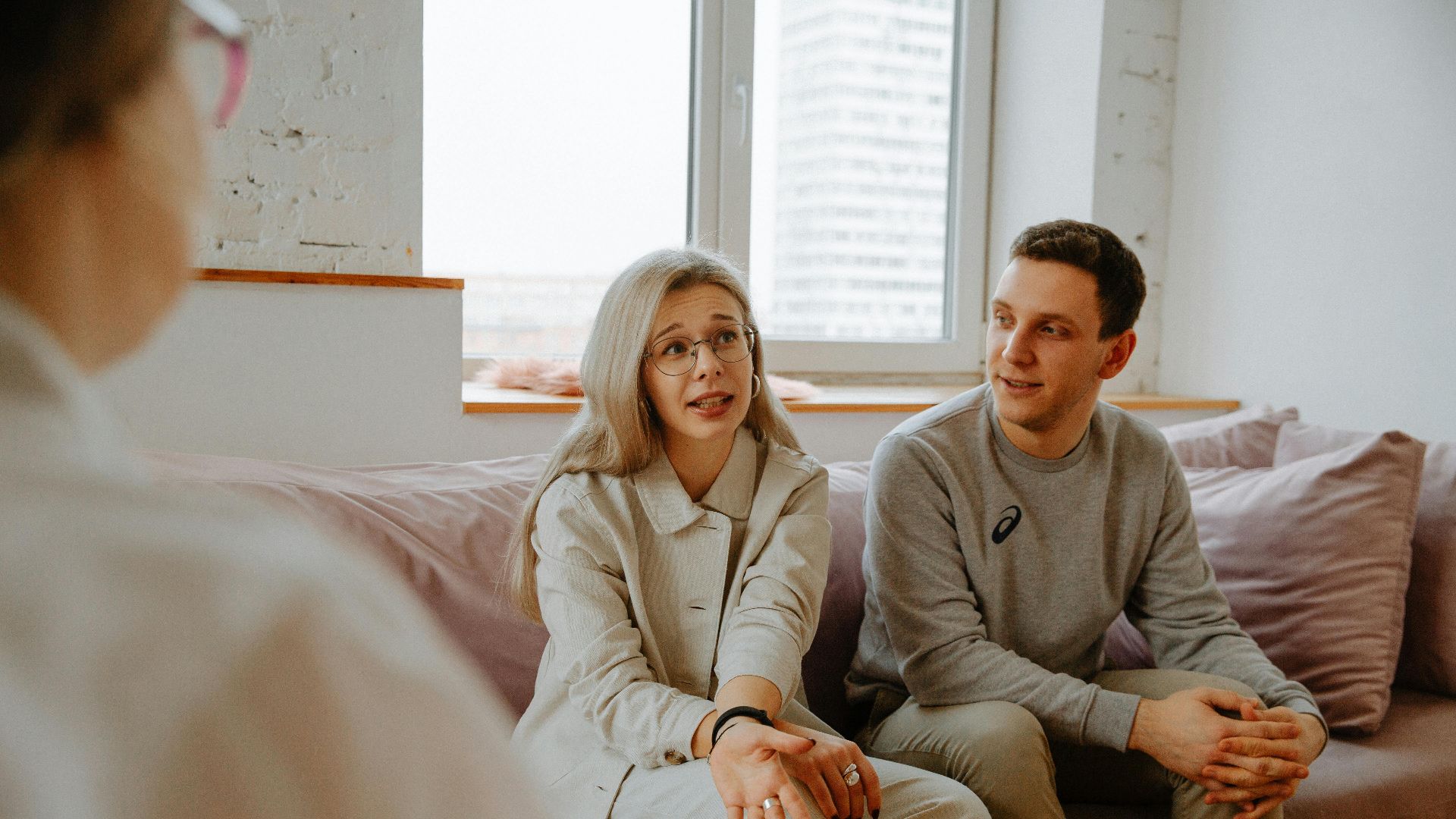 A couple and therapist engaged in a discussion during a therapy session indoors.