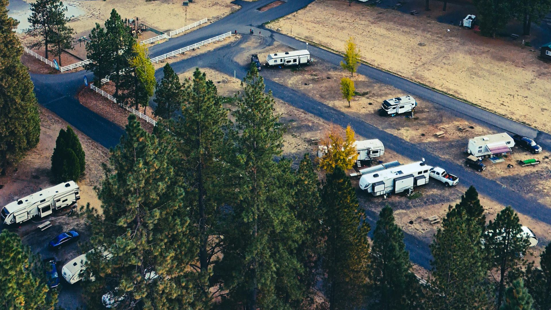 Scenic aerial view of RV camp in forest with autumn foliage.