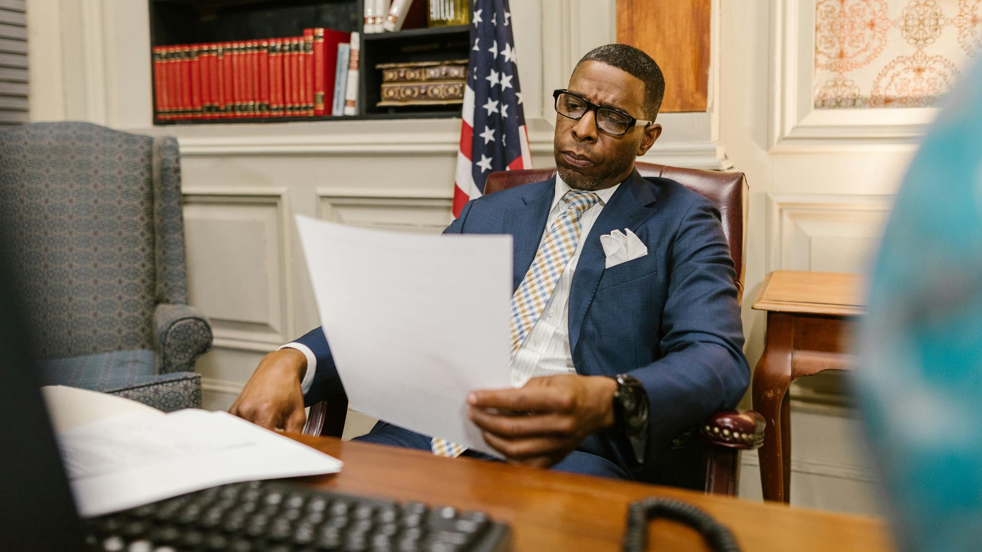 A lawyer attentively reviewing documents at his desk in a law office setting.