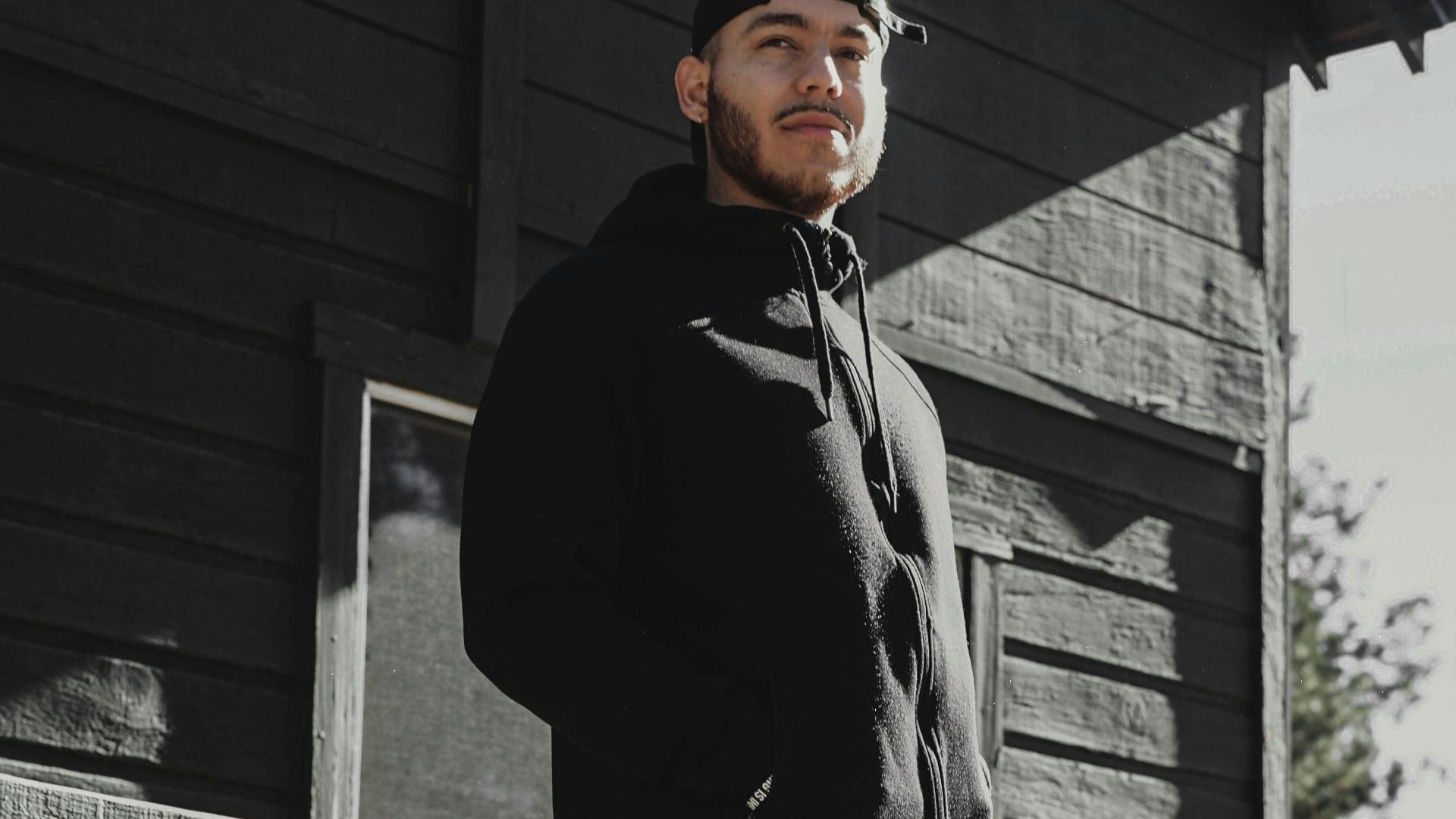 Casual portrait of a young man standing on a cabin porch in Big Bear, CA.