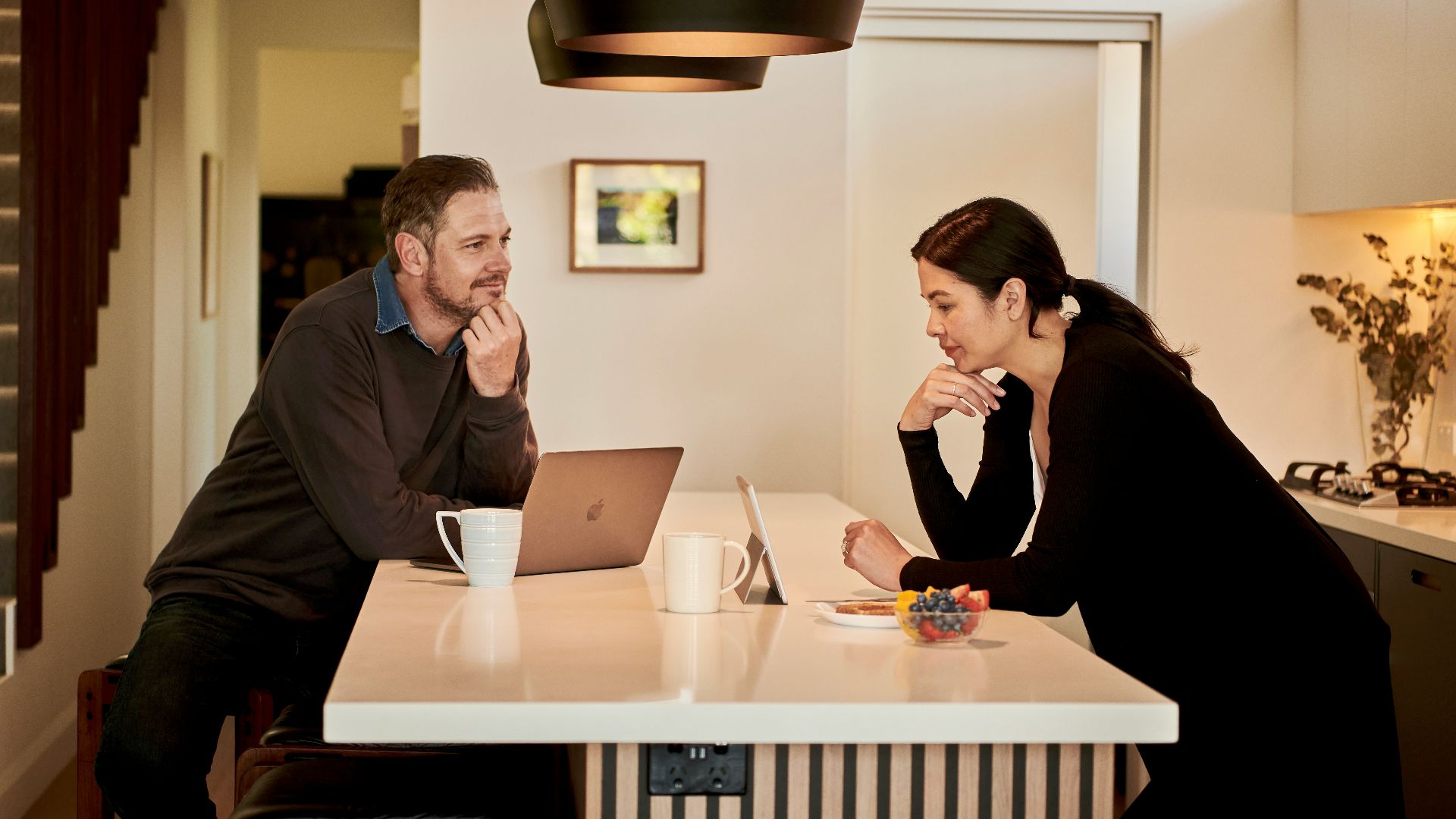 man sitting beside woman in kitchen
